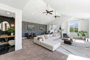 Carpeted living room featuring an accent wall, a high ceiling, recessed lighting, wallpapered walls, and ceiling fan