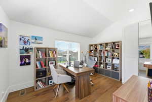 Office area featuring vaulted ceiling and wood finished floors