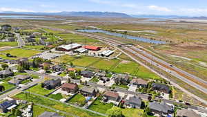 Aerial view of property and surrounding area featuring a water and mountain view and nearby suburban area