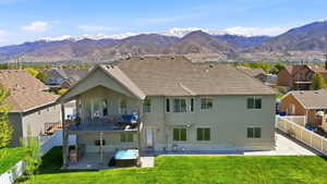 Back of house featuring stucco siding, a patio, a fenced backyard, a residential view, and a mountain view
