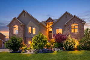 Traditional-style home with stucco siding, a front yard, and stone siding