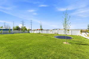 Fenced backyard with a trampoline