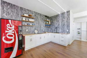 Bar area featuring open shelves, white cabinetry, wooden counters, dark wood-type flooring, and a textured ceiling