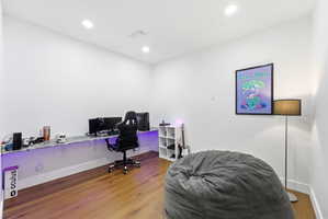 Office area with wood finished floors and recessed lighting