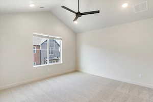 Carpeted room featuring a vaulted ceiling with a ceiling fan, recessed lighting, and a large window with blinds