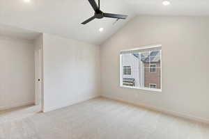 Vaulted ceiling room featuring light neutral carpeting, a large window with blinds, recessed lighting, and a modern black ceiling fan