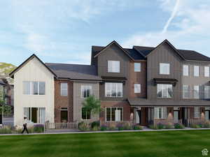 Contemporary townhome exterior featuring a combination of vertical siding, brick accents, and a dark shingle roof