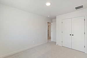 Carpeted room with a double-door closet featuring black hardware