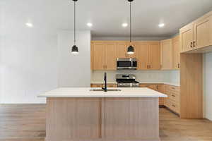 Kitchen featuring light wood-finish cabinetry and a central island with a light-toned countertop