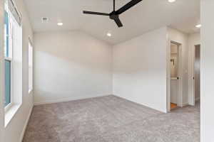 Spacious room featuring vaulted ceilings, recessed lighting, a modern black ceiling fan, two large windows, and plush carpeting