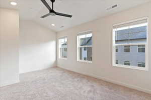 Spacious room featuring vaulted ceilings, recessed lighting, a ceiling fan with integrated lighting, three large windows with blinds, and light-colored carpeting