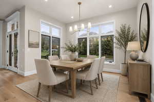 Dining area featuring wood-finish flooring, a contemporary chandelier, recessed lighting, and expansive windows