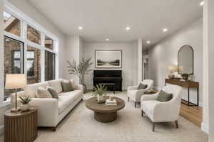 Spacious living area featuring large picture windows, recessed lighting, light-toned walls, wood-finish flooring, and a large area rug