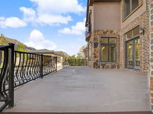 Expansive exterior patio featuring a concrete surface and decorative metal railings