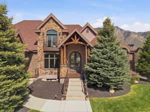 Exterior stone and brick residence featuring a prominent covered entry with wood beam accents