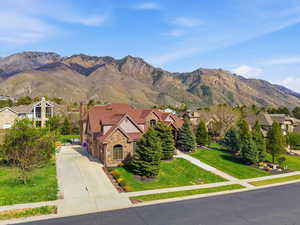 Stone and stucco exterior residence featuring a multi-gabled roofline and attached garage
