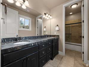 Dual vanity with dark cabinetry and patterned countertop