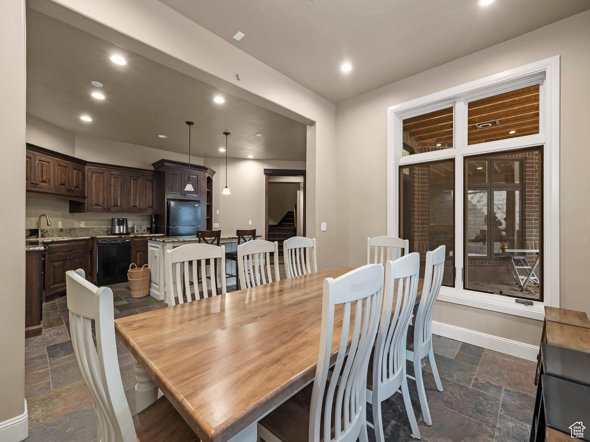 Open-concept dining area featuring wood-finish flooring and a large window with white trim