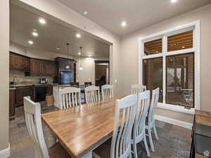 Open-concept dining area featuring wood-finish flooring and a large window with white trim