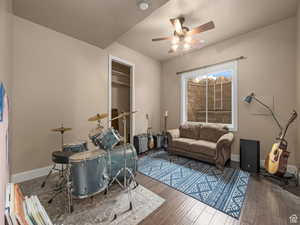 Versatile room featuring wood-finish flooring, a window, and a ceiling fan