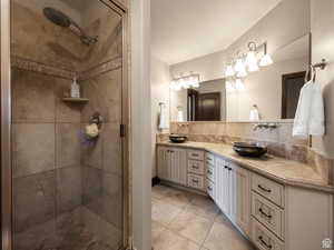 Dual vanity with vessel sinks, extensive countertop space, wood-finish cabinetry, and a full-width mirror