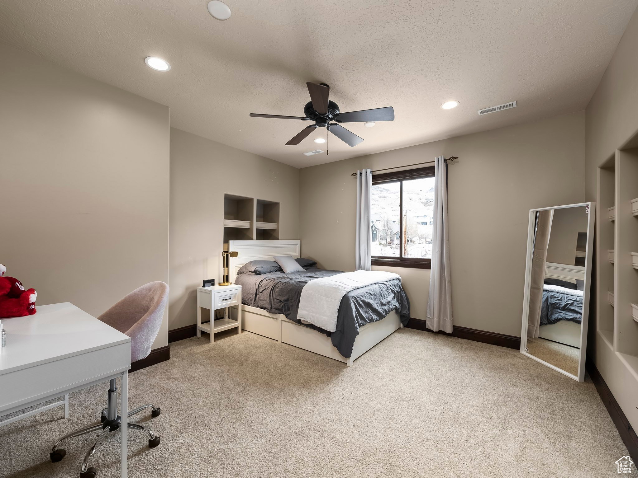 Plush carpeting and a ceiling fan with integrated lighting