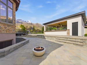 Expansive stone paver patio featuring a built-in fire pit
