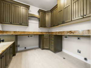 Utility room featuring extensive wood cabinetry, granite-finish countertops, wood-finish flooring, and a built-in hanging rod