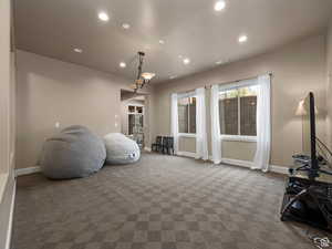 Spacious room featuring patterned carpet flooring, recessed lighting, and a multi-light chandelier