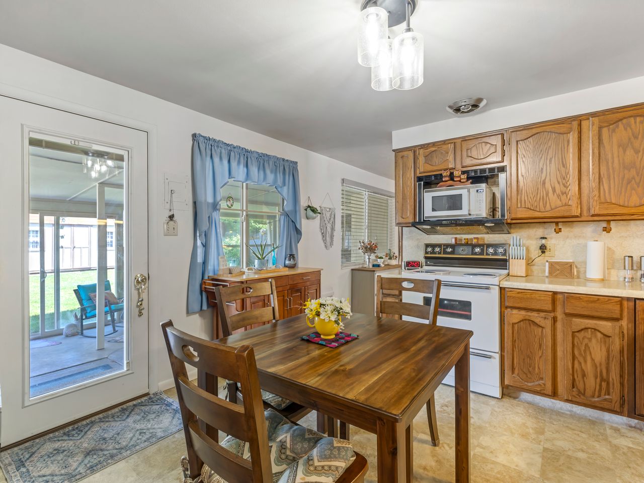 Kitchen featuring wood cabinetry, light-toned countertops, and a full suite of appliances