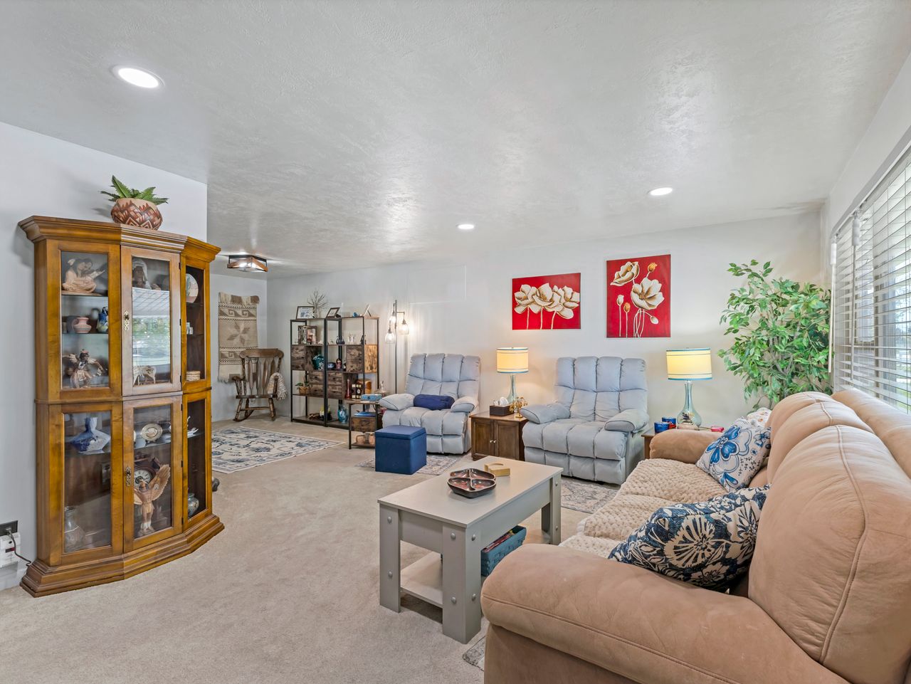 Spacious living area featuring neutral carpeting and recessed lighting