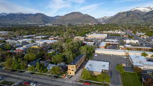 Aerial perspective featuring a building under construction, commercial structures, residential areas, and a mountainous backdrop