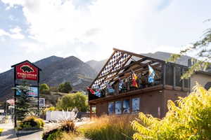 Commercial building featuring a second-story outdoor patio with an open-air roof structure and mountain backdrop