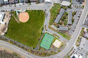 Aerial perspective showcasing a baseball field, two tennis courts, and adjacent green spaces