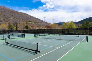 Multi-court facility featuring hard-surface courts, permanent netting, and perimeter fencing