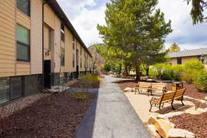 Outdoor seating area featuring two wooden benches on a paver patio