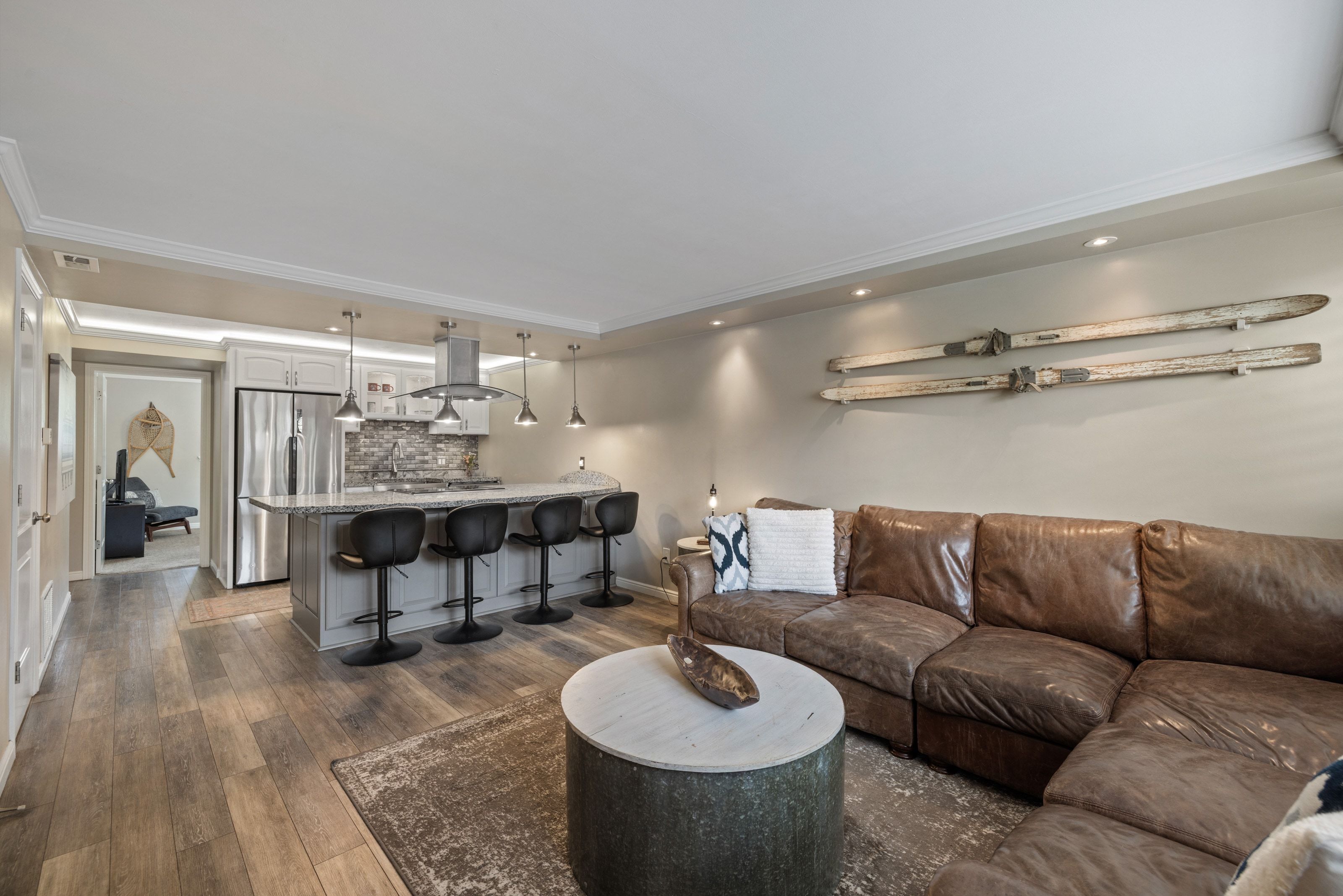 Open concept living area featuring wood-finish flooring, recessed lighting, and crown molding