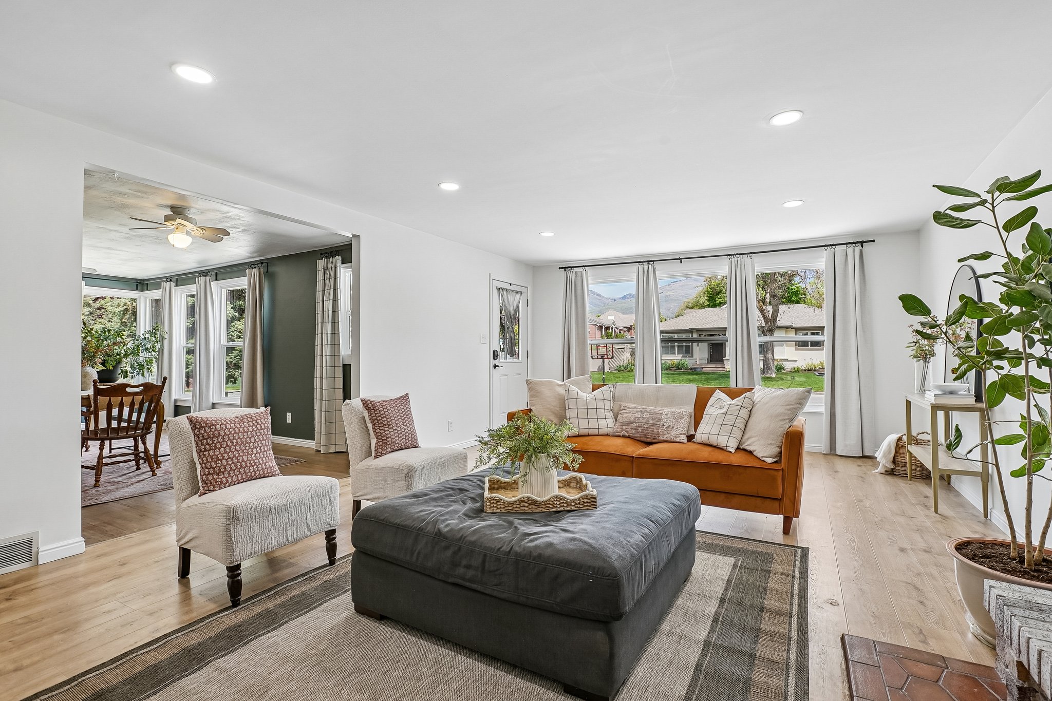 Bright living area featuring wood-finish flooring, recessed lighting, and large windows