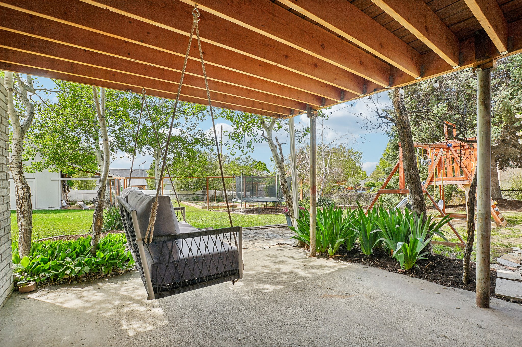 Covered patio area featuring a concrete surface and exposed wood beam ceiling