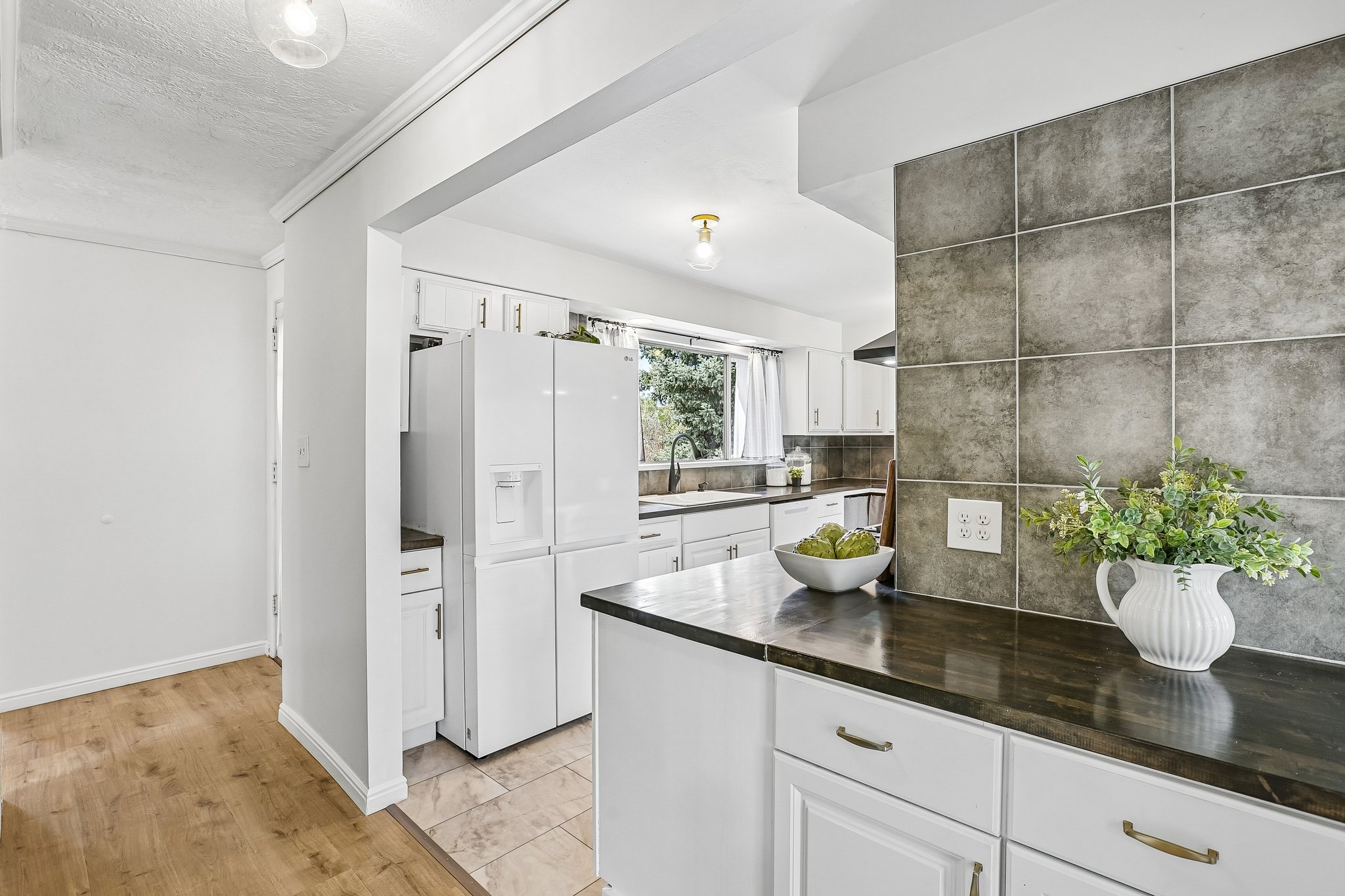 Kitchen featuring white cabinetry, dark countertops, a tiled backsplash, and recessed lighting