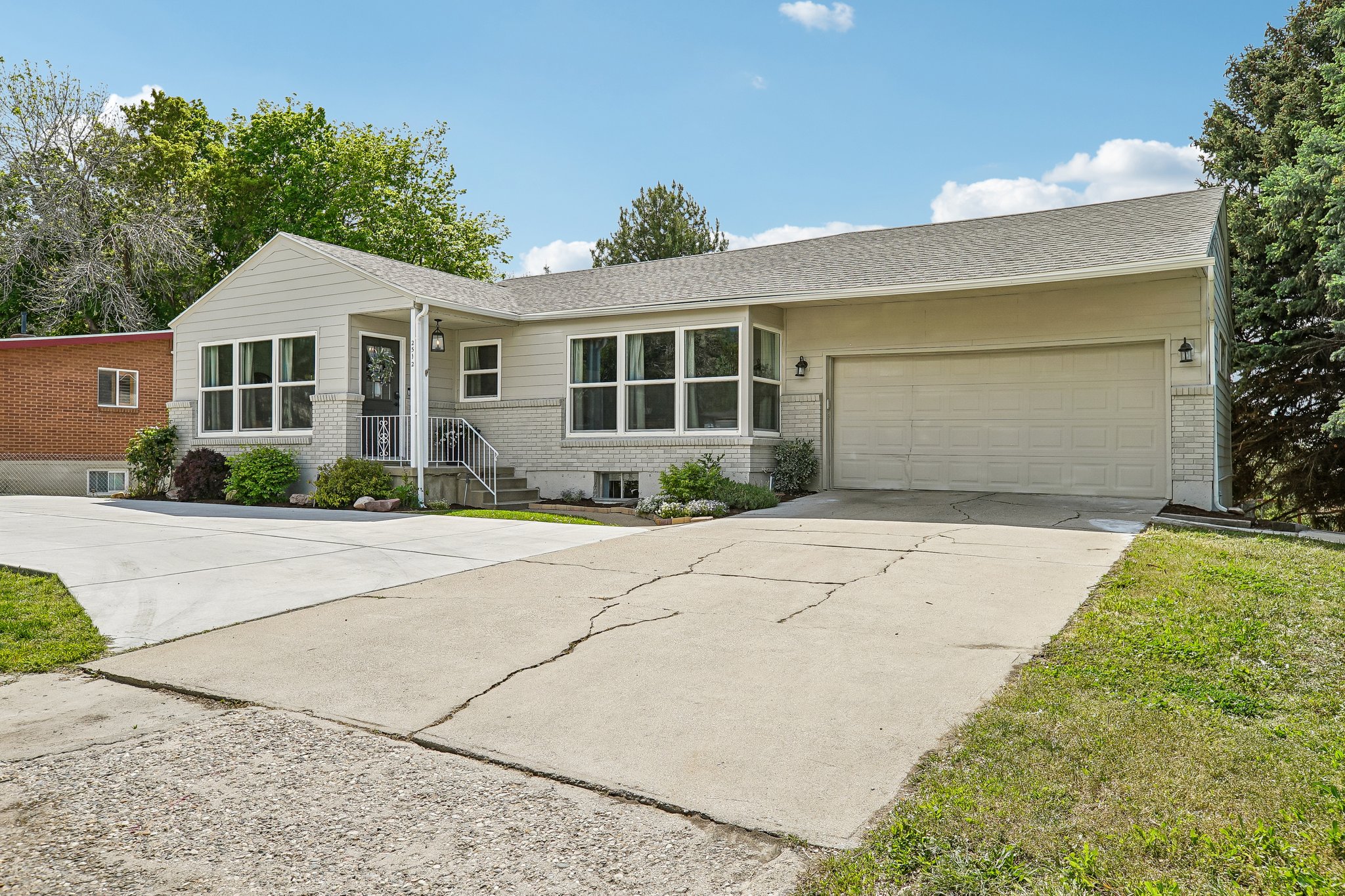 Ranch-style exterior with light gray siding and a light gray brick foundation