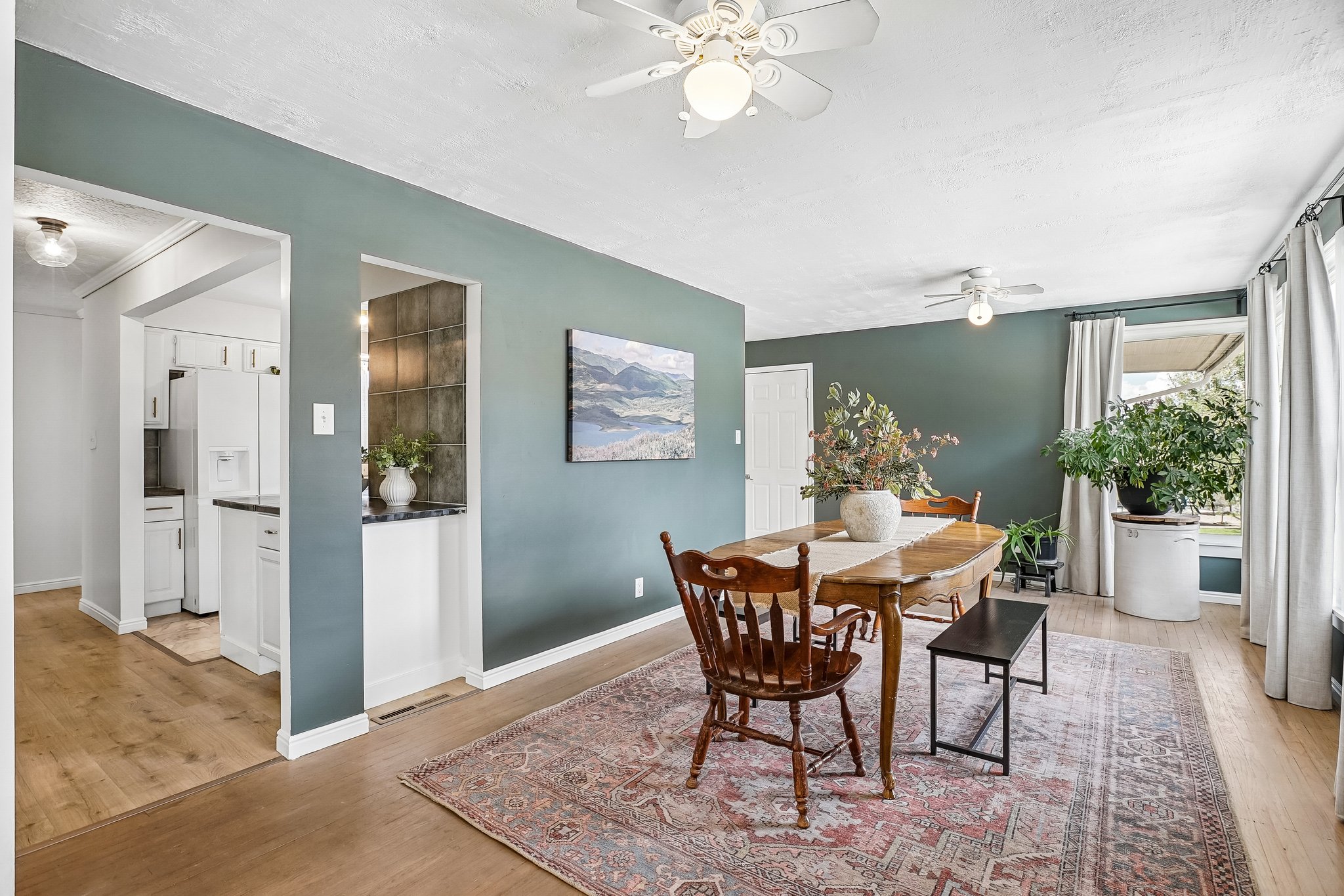 Spacious dining area featuring wood-finish flooring and a ceiling fan