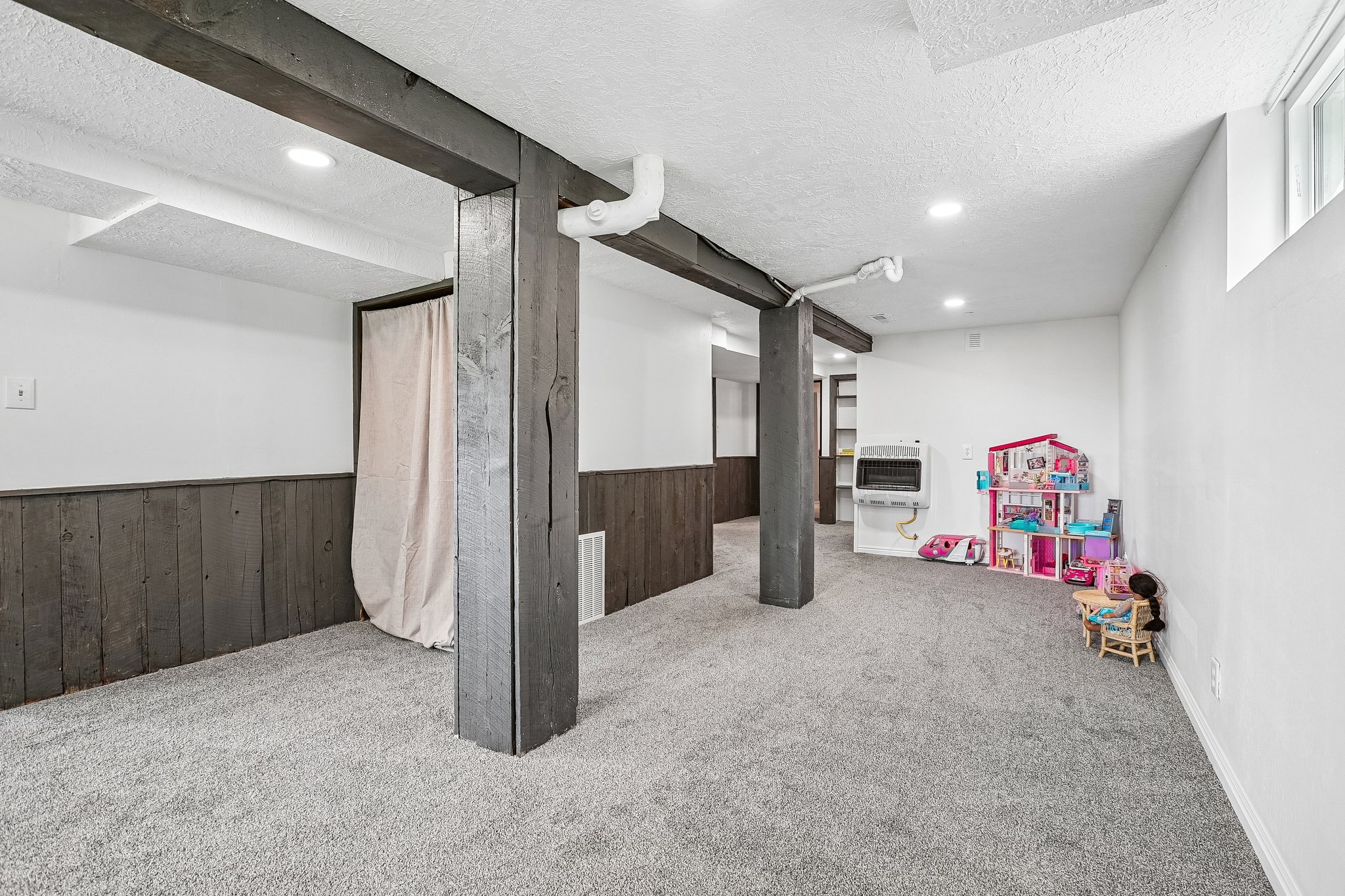 Spacious room with gray carpeting and white walls