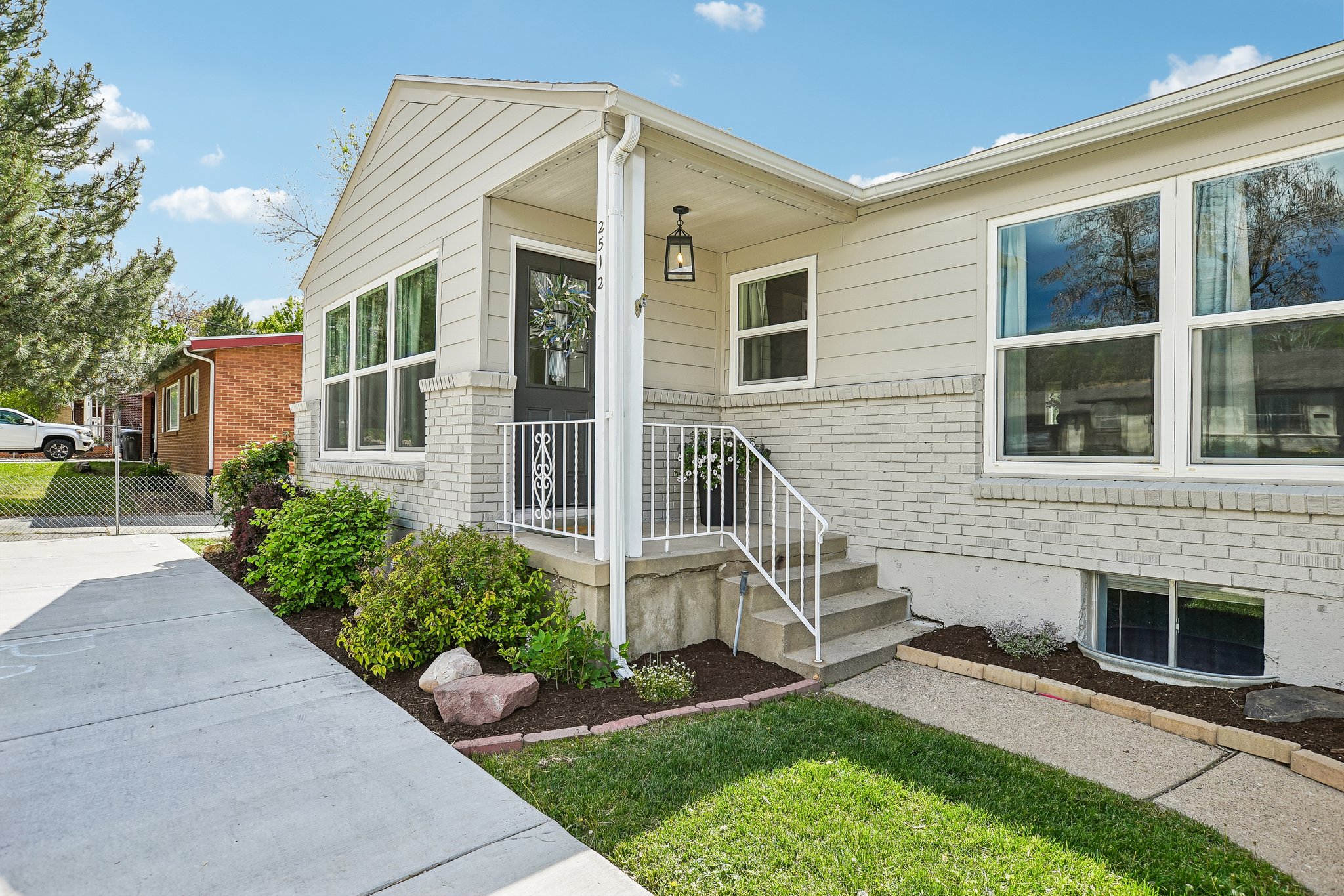 Light-colored siding exterior with a contrasting dark front door