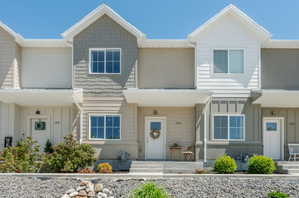 Multi-unit dwelling featuring a varied facade with horizontal siding, shake siding, and stucco finishes