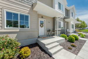 Concrete entry steps leading to a front door with an overhead awning