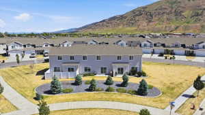 Townhome property featuring a light gray exterior, white privacy fences, and a landscaped backyard area
