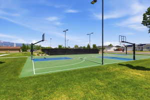 Recreational basketball court featuring two full-size hoops and a green and blue playing surface