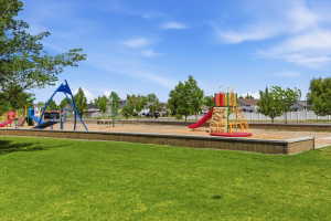 Expansive grassy area bordering a designated playground