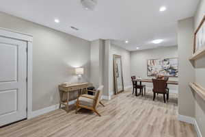 Spacious room featuring wood-finish flooring, recessed lighting, and a neutral color palette
